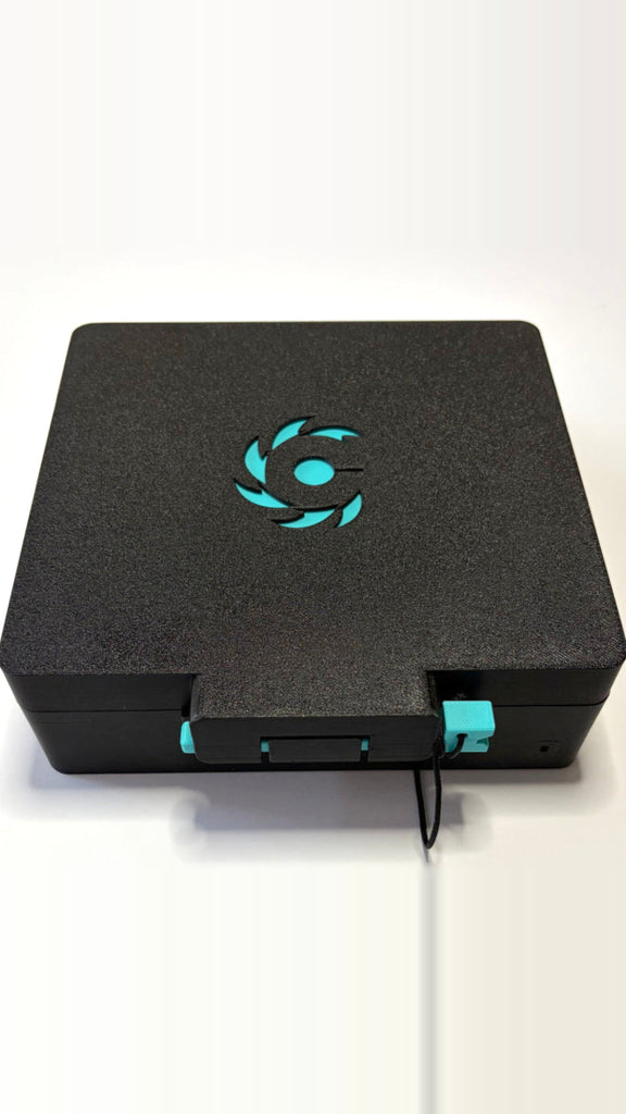 Beycrate 1 in Hyper Cyan, closed, showing the matte-black shell, cyan lock pin and Beycrate logo tile